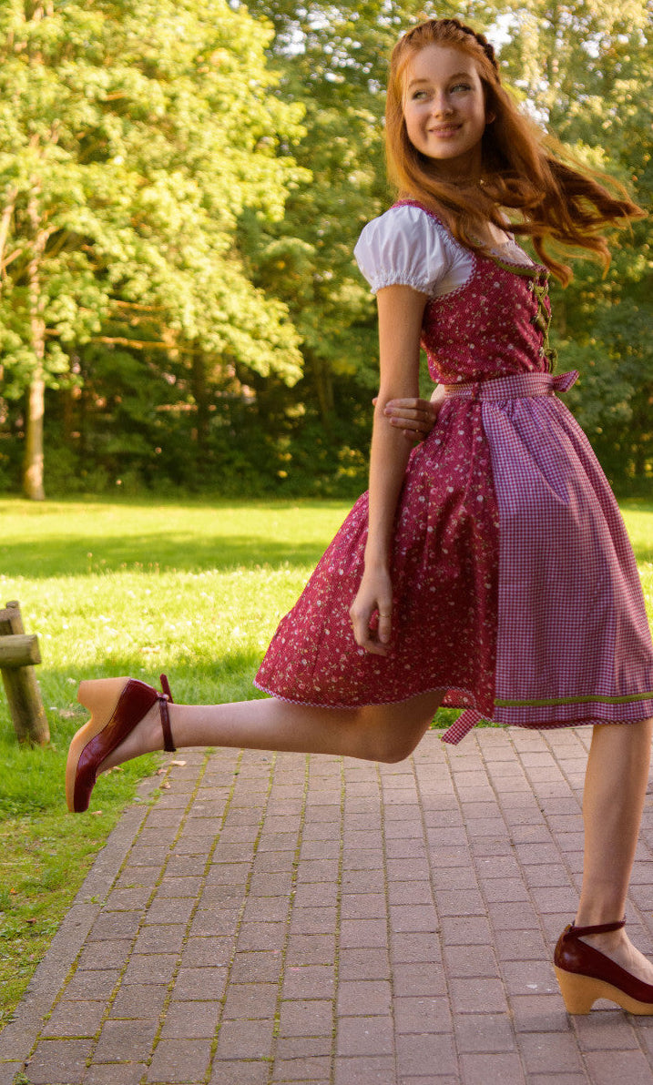 Dirndl Elli in Rot mit karierter Schürze in Bewegung