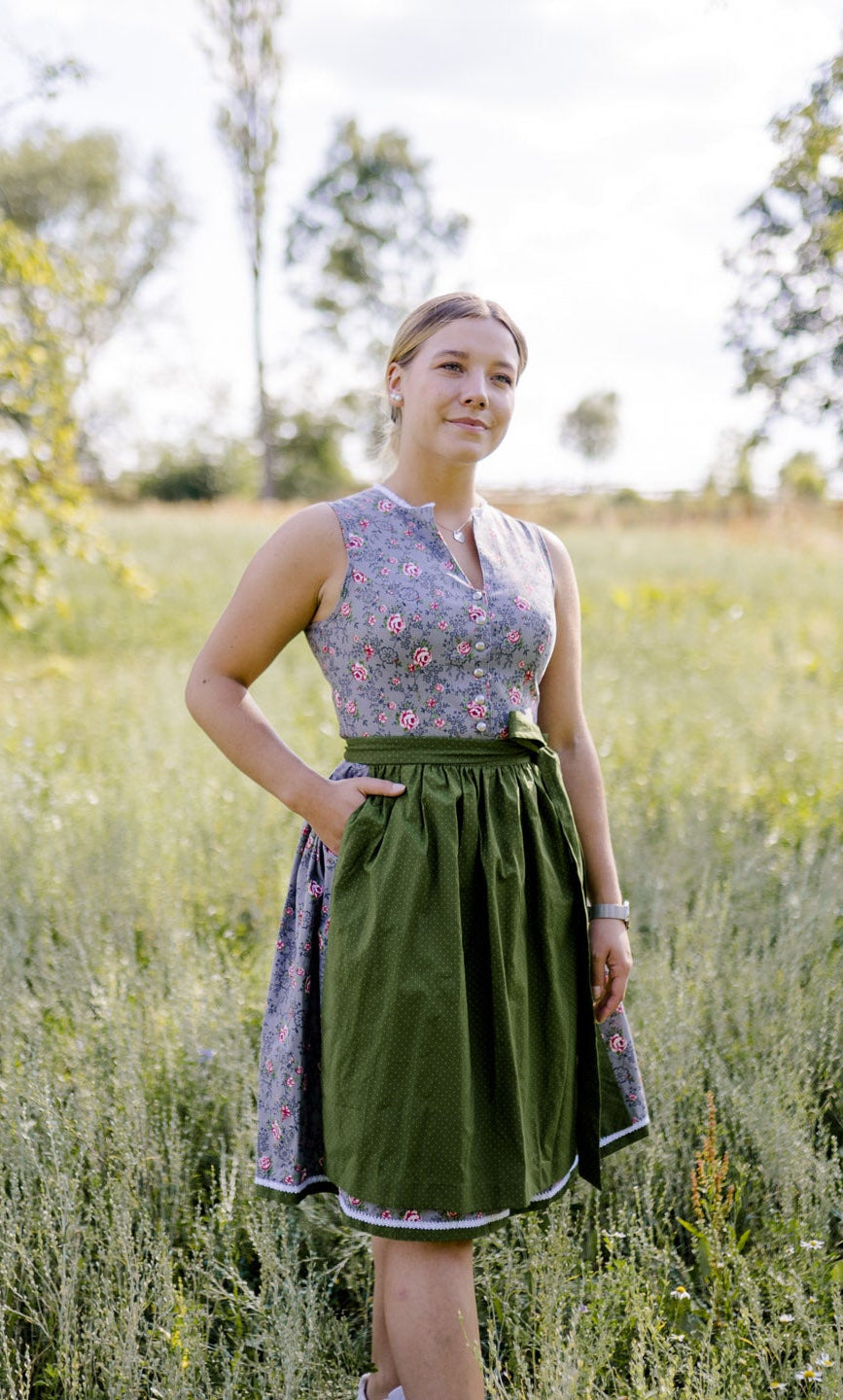 graues Dirndl mit grüner Schürze Modelbild Wiese