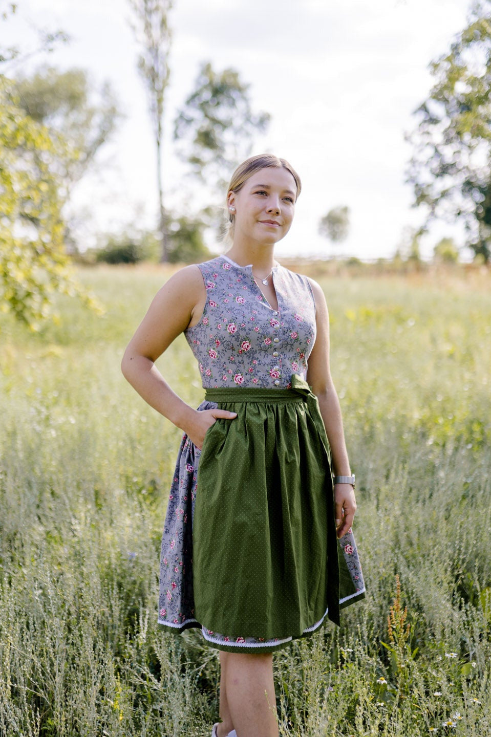 graues Dirndl mit grüner Schürze Modelbild Wiese