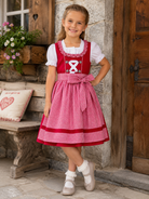 Mädchen trägt das Kinderdirndl Nele in Rot