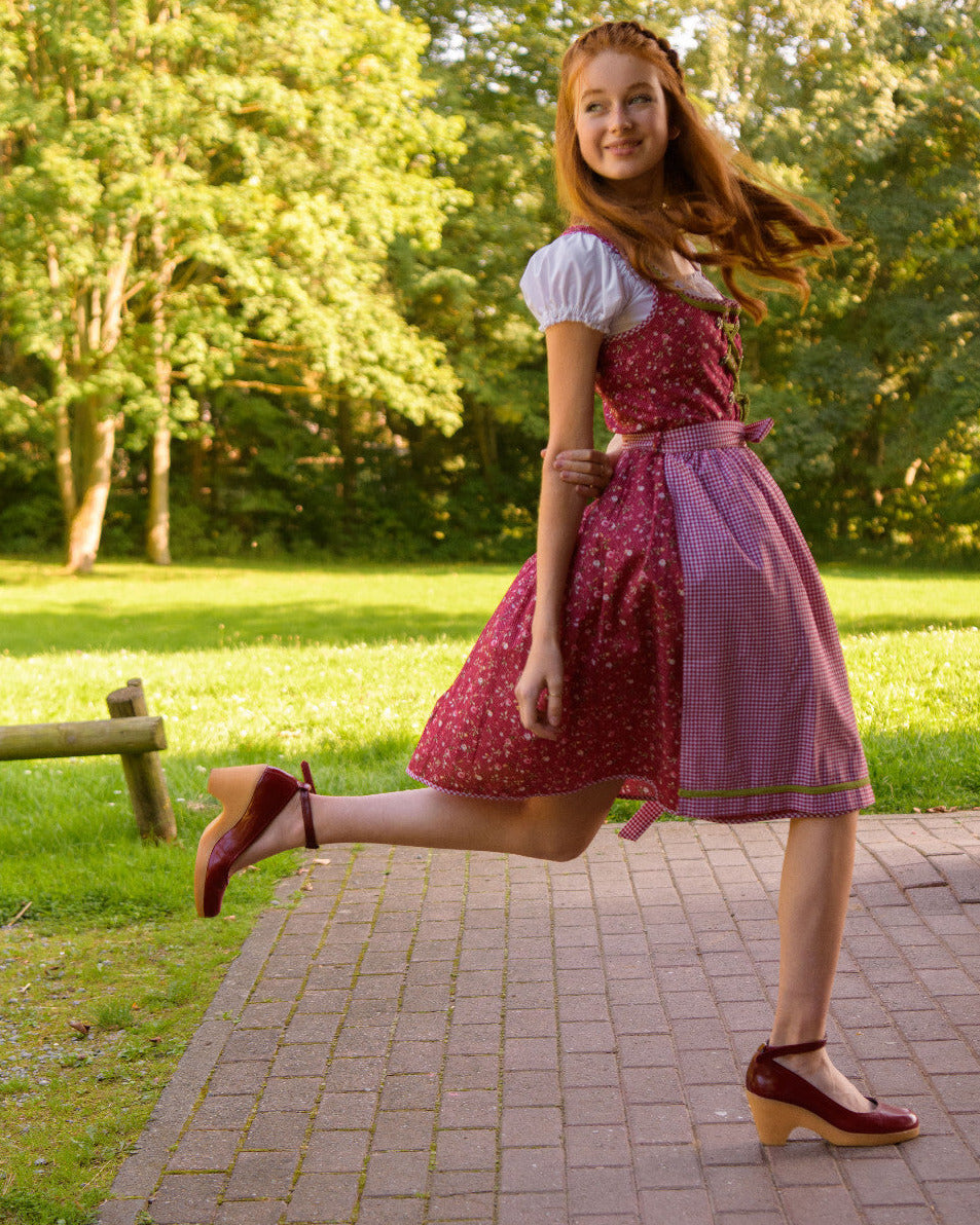 Dirndl Elli in Rot  mit karierter Schürze in Bewegung