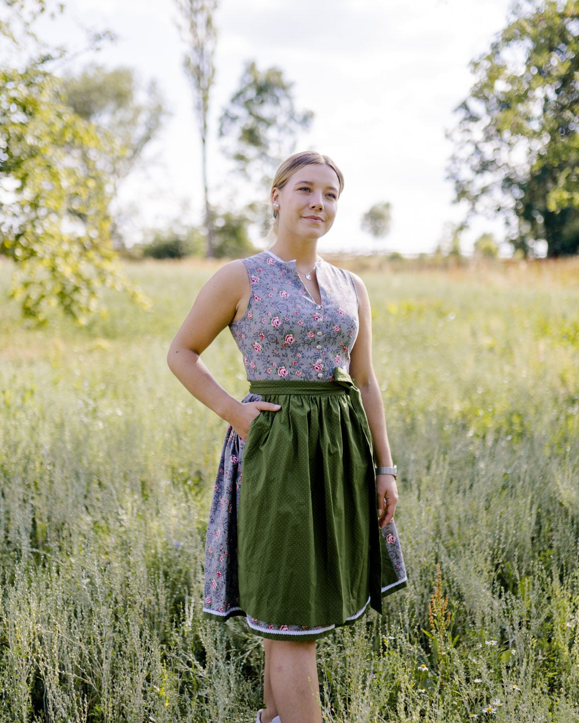 graues Dirndl mit grüner Schürze Modelbild Wiese
