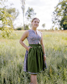 graues Dirndl mit grüner Schürze Modelbild Wiese